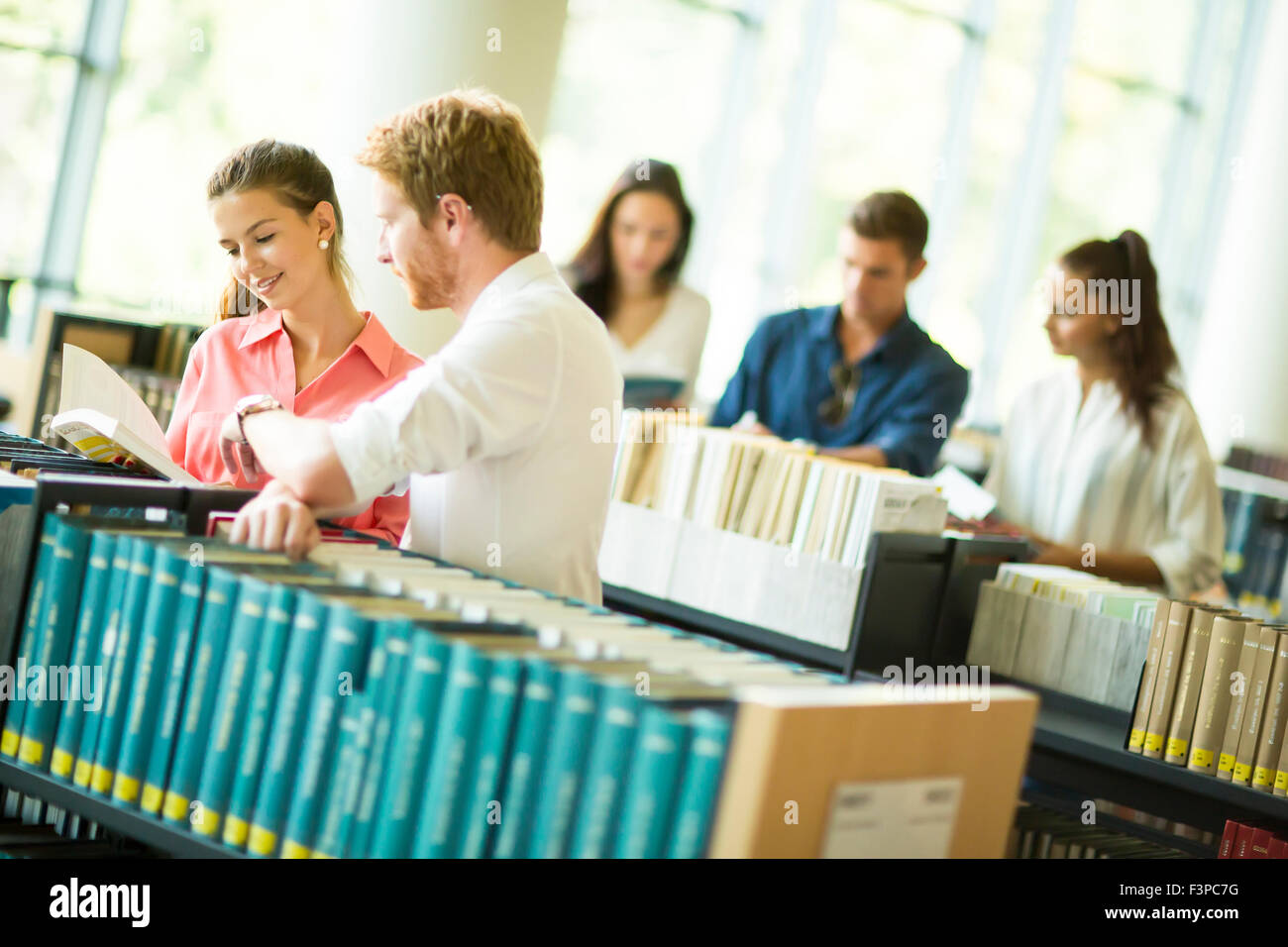 Young people in the library Stock Photo - Alamy