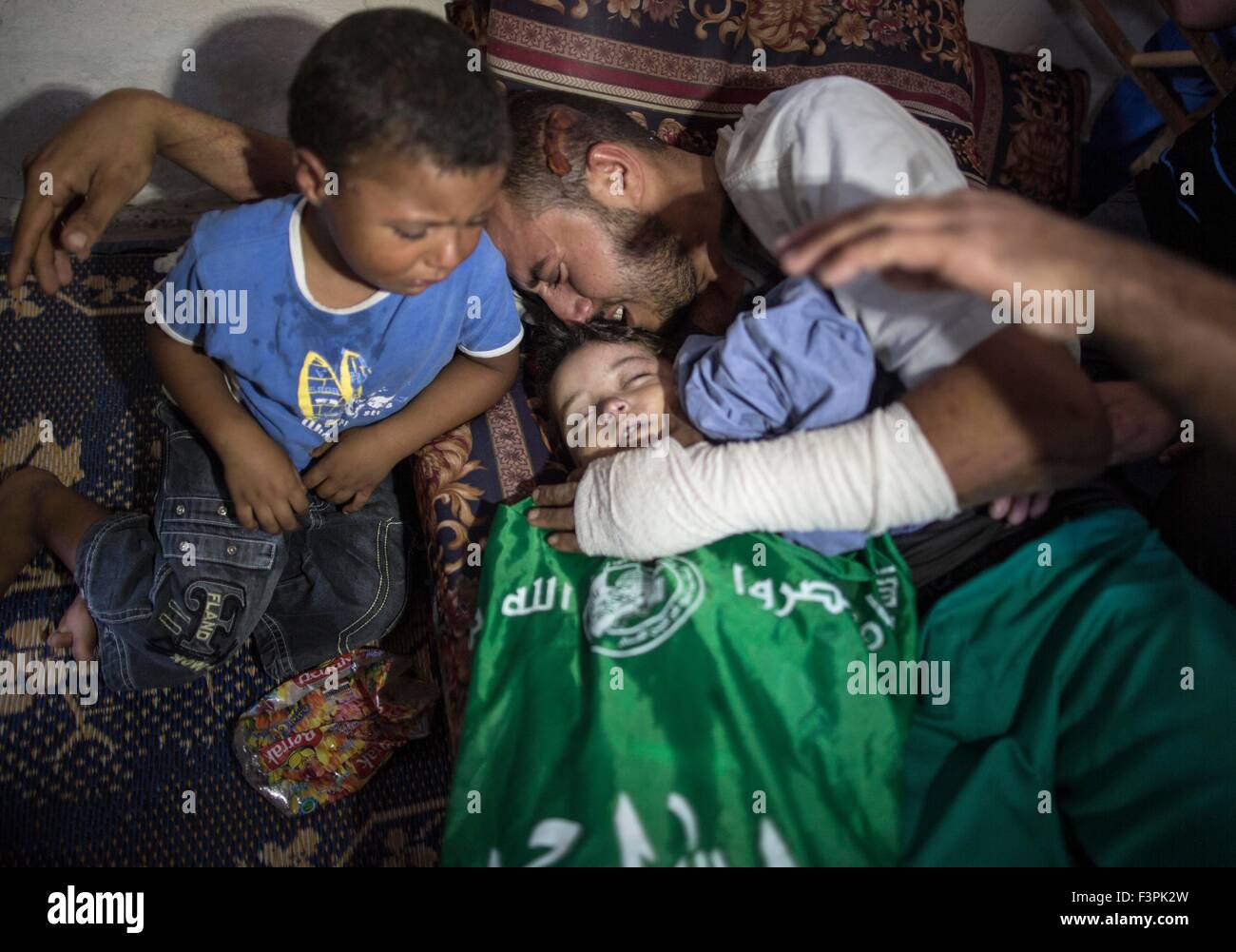 Gaza. 11th Oct, 2015. The wounded father of Palestinian girl Rahaf Hassan, 2 years old, hugs the body of his daughter during her funeral at the al-Nusairat refugee camp in central Gaza Strip on Oct. 11, 2015. Rahaf and her pregnant mother were killed after their house collapsed in an Israeli air strike. © Wissam Nassar/Xinhua/Alamy Live News Stock Photo