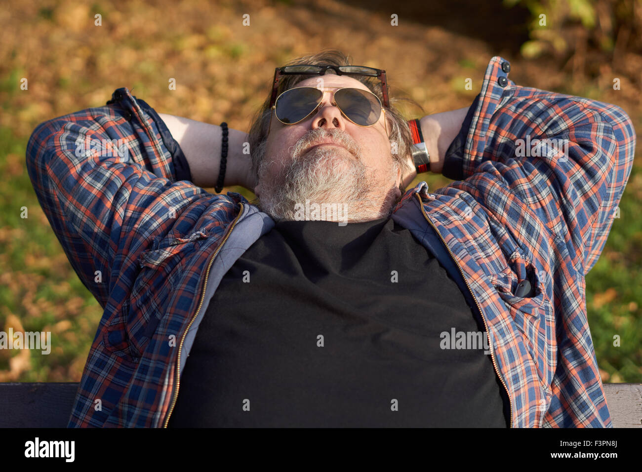 Man holds hands behind his head and has rest Stock Photo