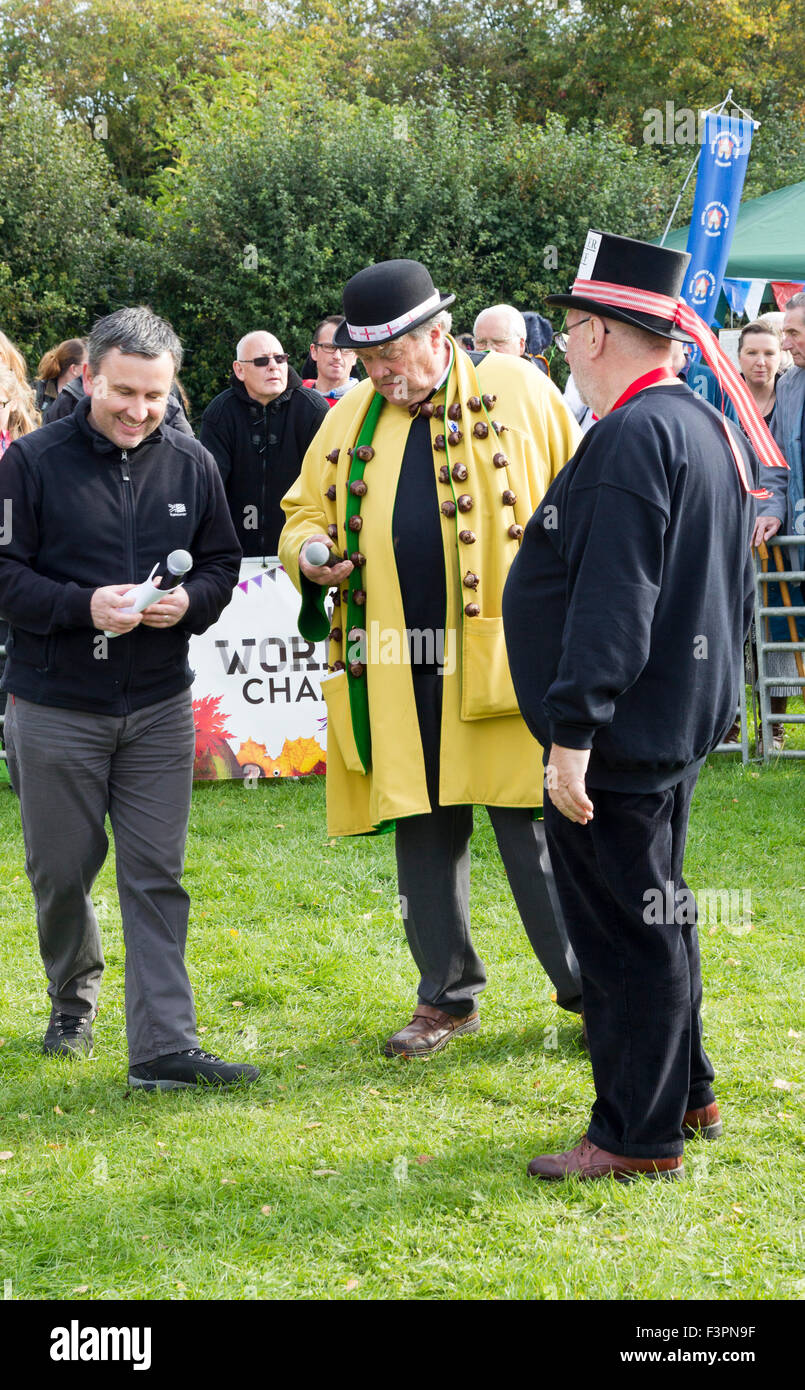 Southwick, Northamptonshire. 2015 World Conker Championship, Sunday 11th October, Celebrating the 50th year since the competition was established, with entrants from as far away as USA, Canada, South America, Australia and Europe David Jakins King Conker )Yellow coat) talking with Master of Ceremonies for 2015 is Mike Sewell from BBC Five Live (on left) and chief umpire (on right) Credit:  Keith J Smith./Alamy Live News Stock Photo