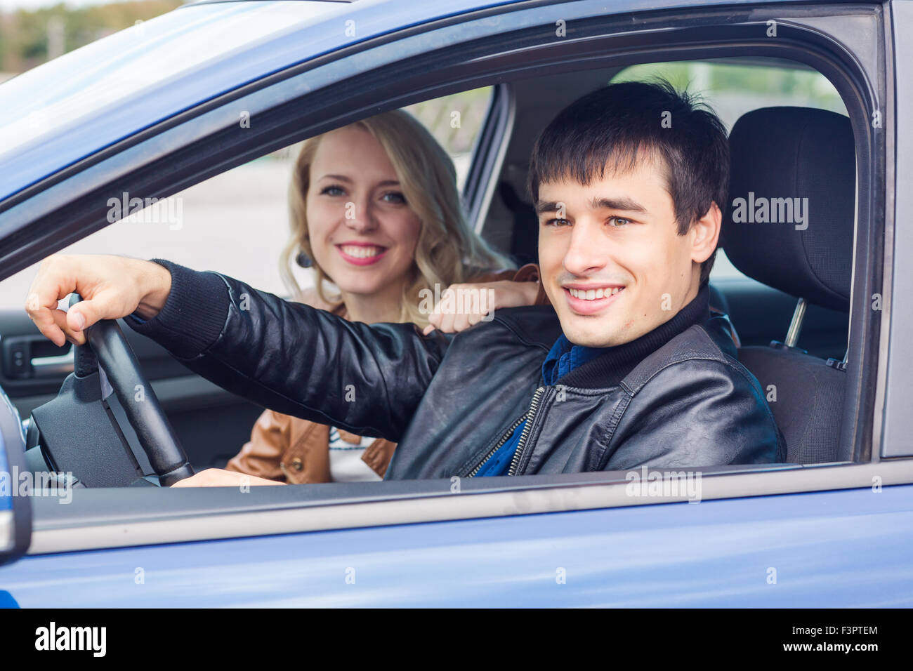 Happy young couple sitting in their car Stock Photo - Alamy