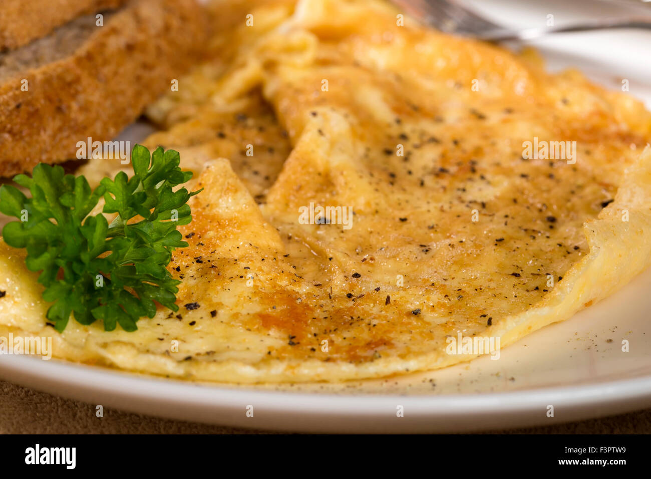 Scrambled eggs on a plate with parsley and pepper Stock Photo