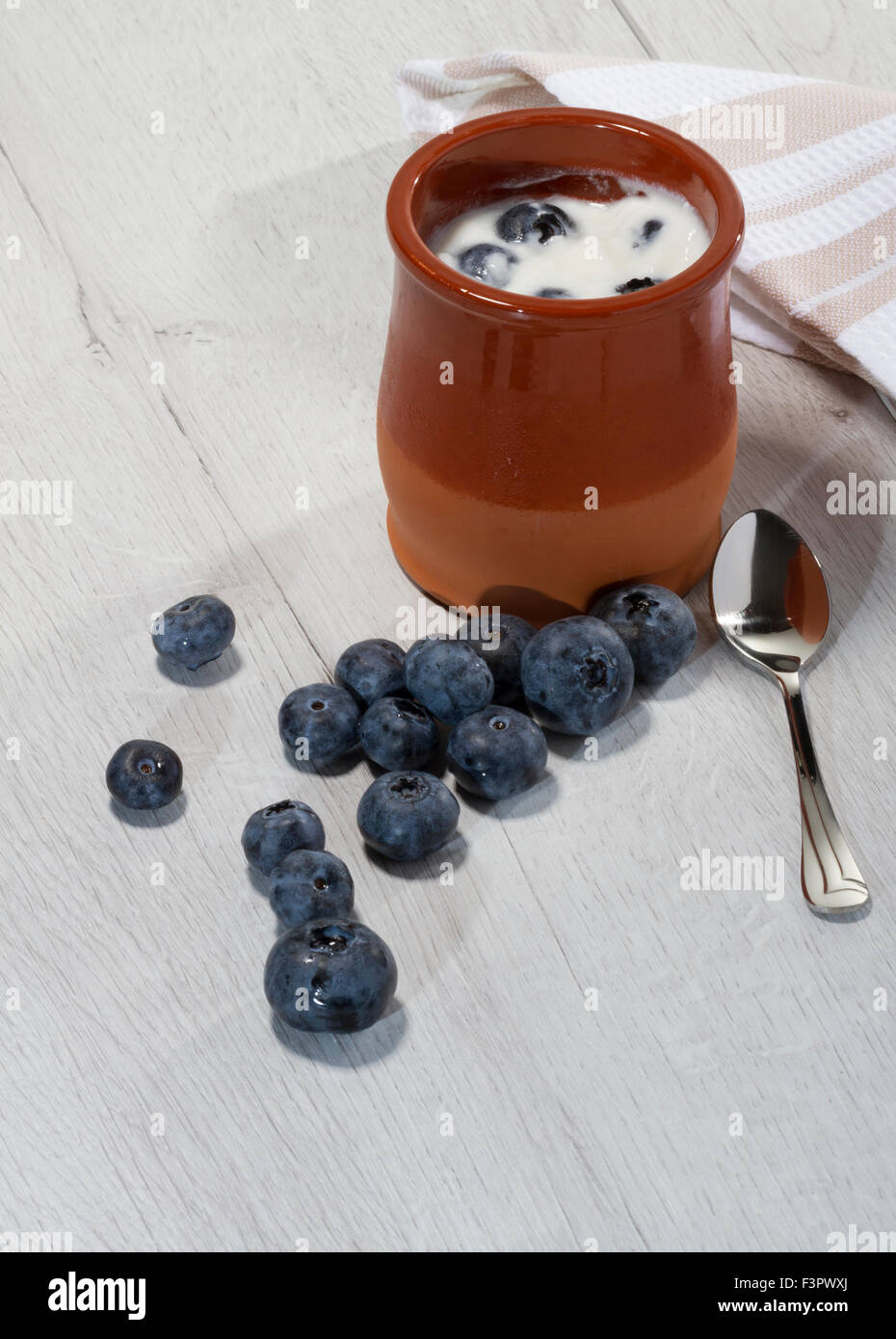 homemade yogurt with blueberries in a traditional clay pot Stock Photo