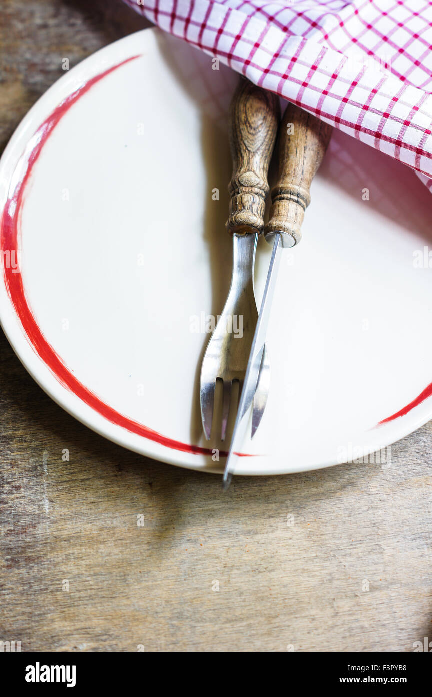 Table Setting with napkin and silverware on wooden table Stock Photo