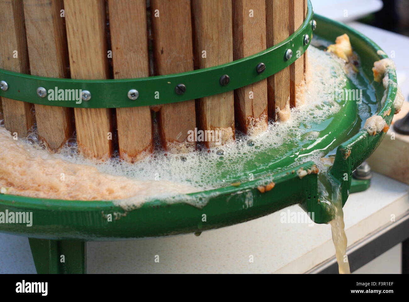 Fresh apple juice flows from an apple press at an Apple Day festival in Sheffield, South Yorkshire, England UK - October Stock Photo