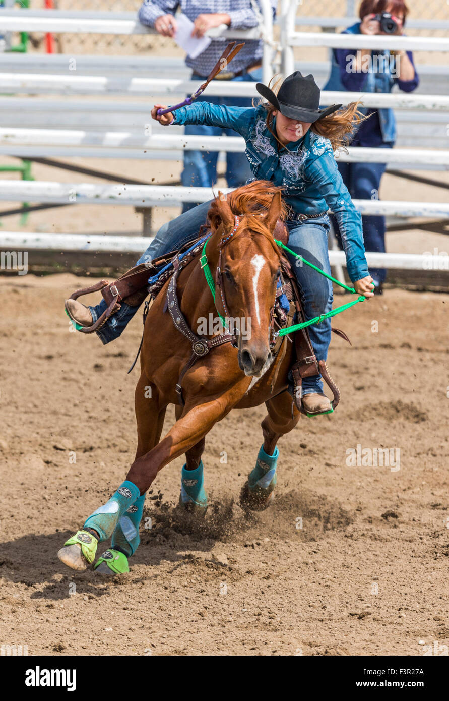 Rodeo cowgirl on horseback competing in barrel racing event, Chaffee