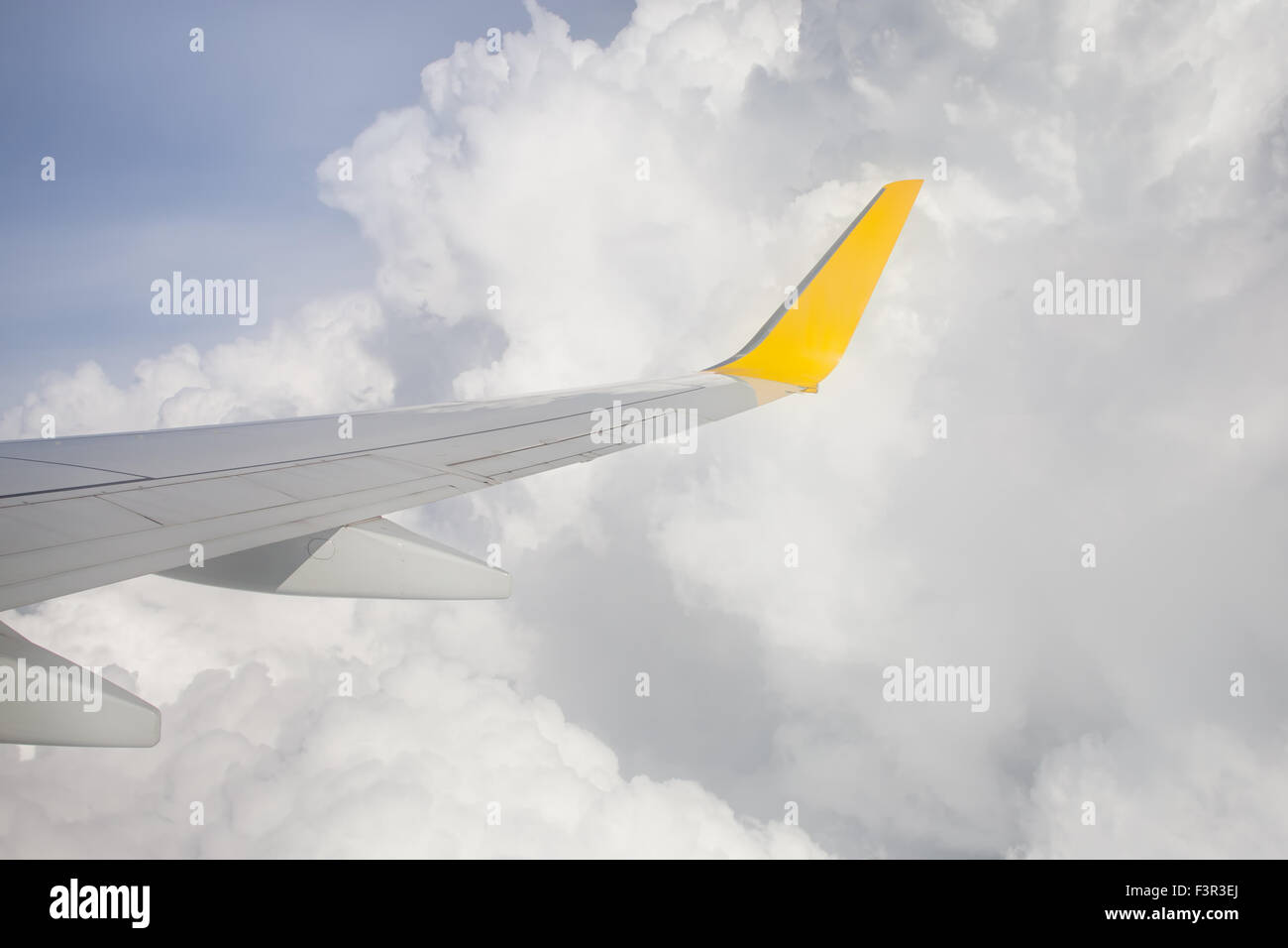 Wing of an airplane flying above the white clouds Stock Photo - Alamy