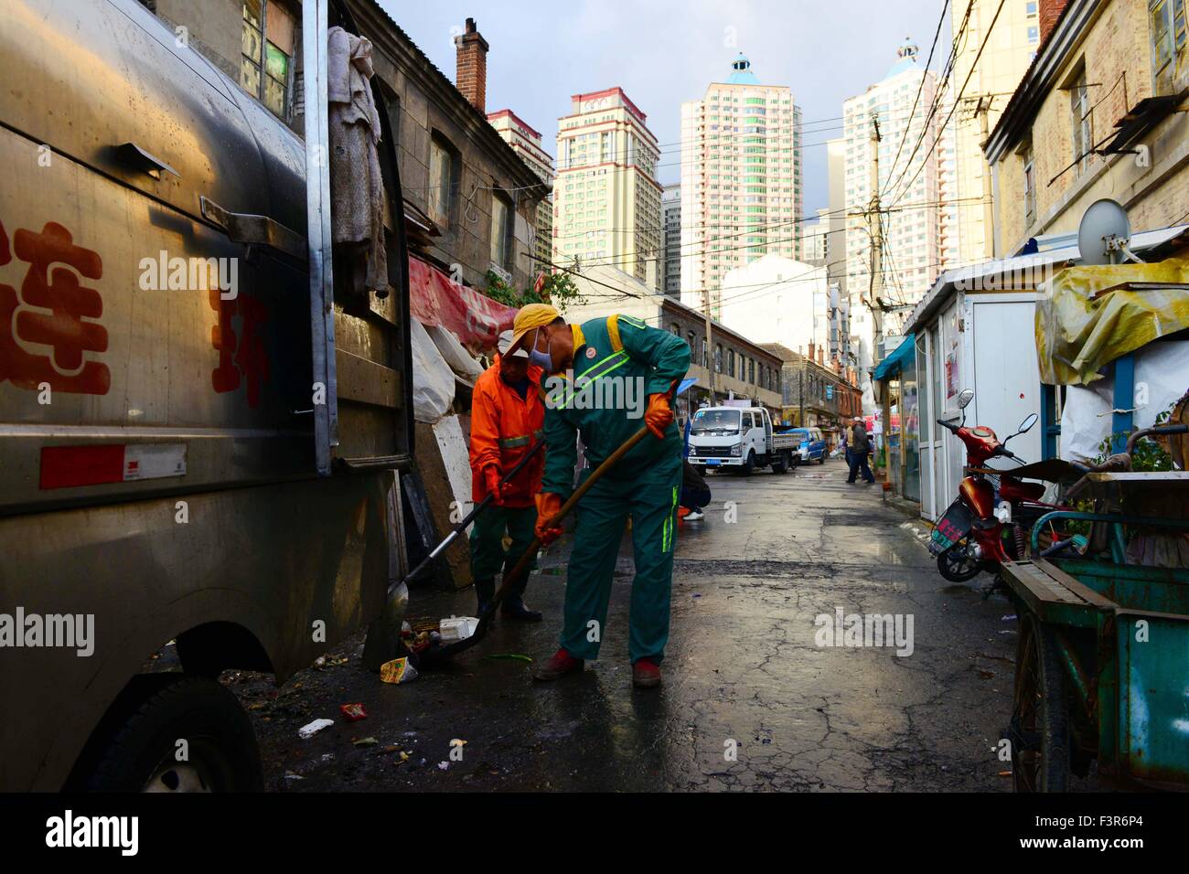 Dalian, China's Liaoning Province. 11th Oct, 2015. Sanitation men work at Dongguan Street in Dalian City, northeast China's Liaoning Province, Oct. 11, 2015. Dongguan Street, a neighborhood with about 100 years history, is scheduled to be reconstructed in 2015, according to the local municipal planning. Credit:  Pu Feng/Xinhua/Alamy Live News Stock Photo