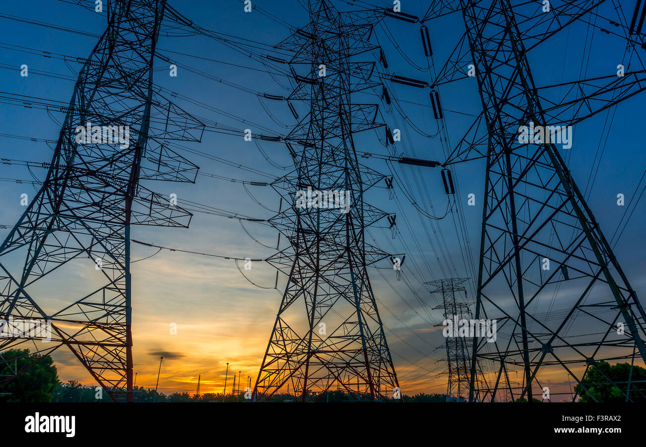 Silhouette of high power transmission towers with sunset background ...