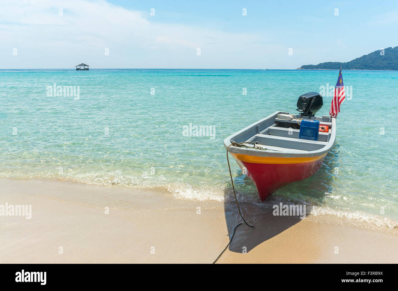 Boat with clear water and blue skies at Perhentian Island, Malaysia ...