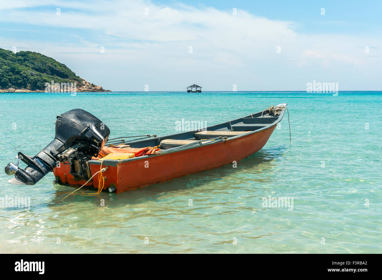 Boat with clear water and blue skies at Perhentian Island, Malaysia ...