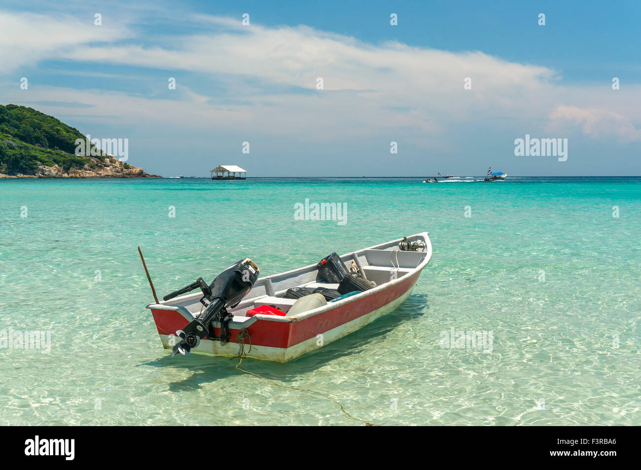 Boat with clear water and blue skies at Perhentian Island, Malaysia ...