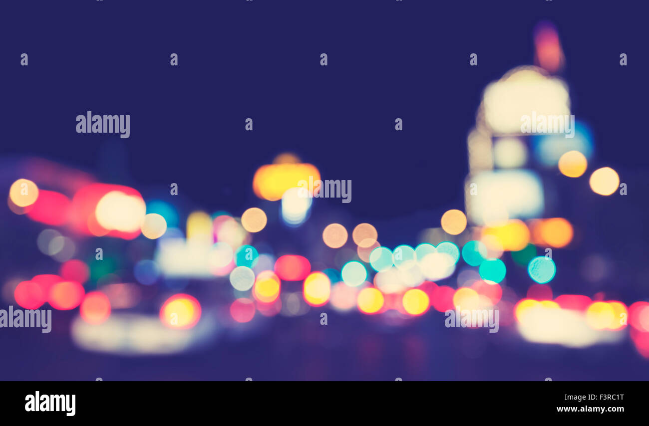 Vintage toned blurred city lights at night, urban abstract background