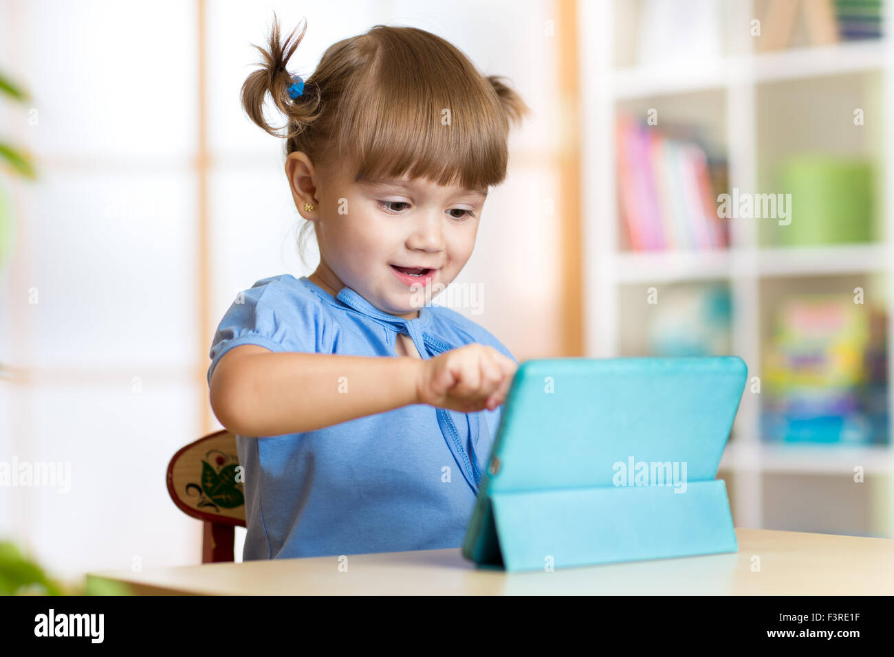 child girl playing with a digital tablet at home Stock Photo - Alamy
