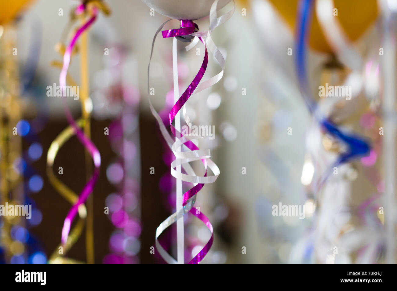 Shiny decorative ribbons hanging from helium balloons Stock Photo - Alamy
