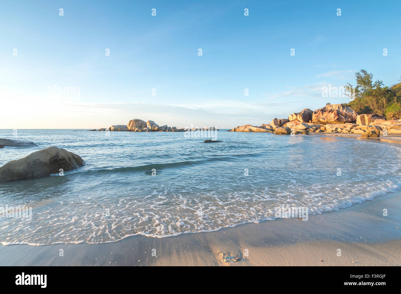 Beach rock with water wave blue skies background Stock Photo - Alamy