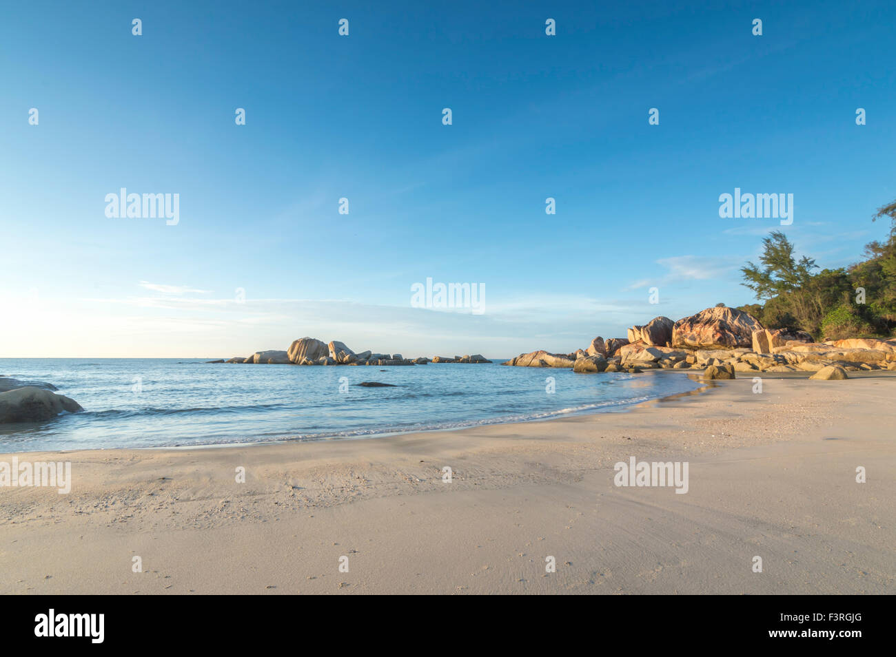 Beach rock with water wave blue skies background Stock Photo - Alamy
