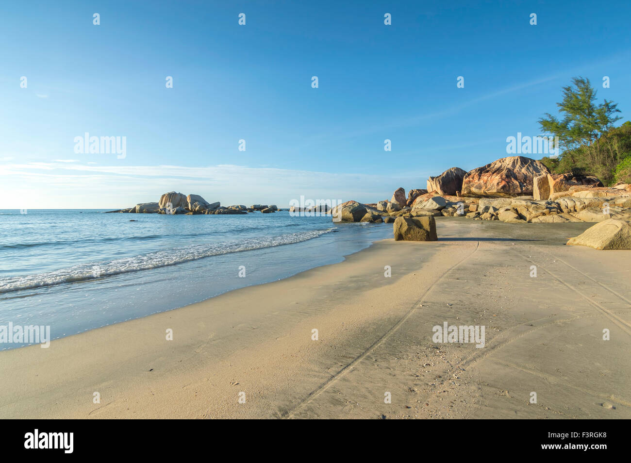 Beach rock with water wave blue skies background Stock Photo - Alamy