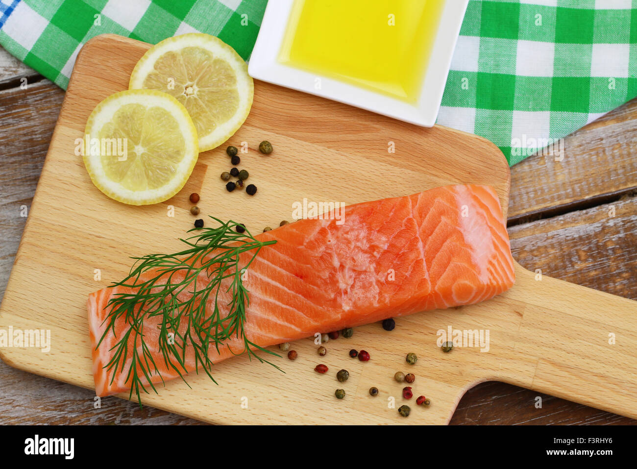 Raw salmon steak on wooden board and fresh lemon and dill Stock Photo