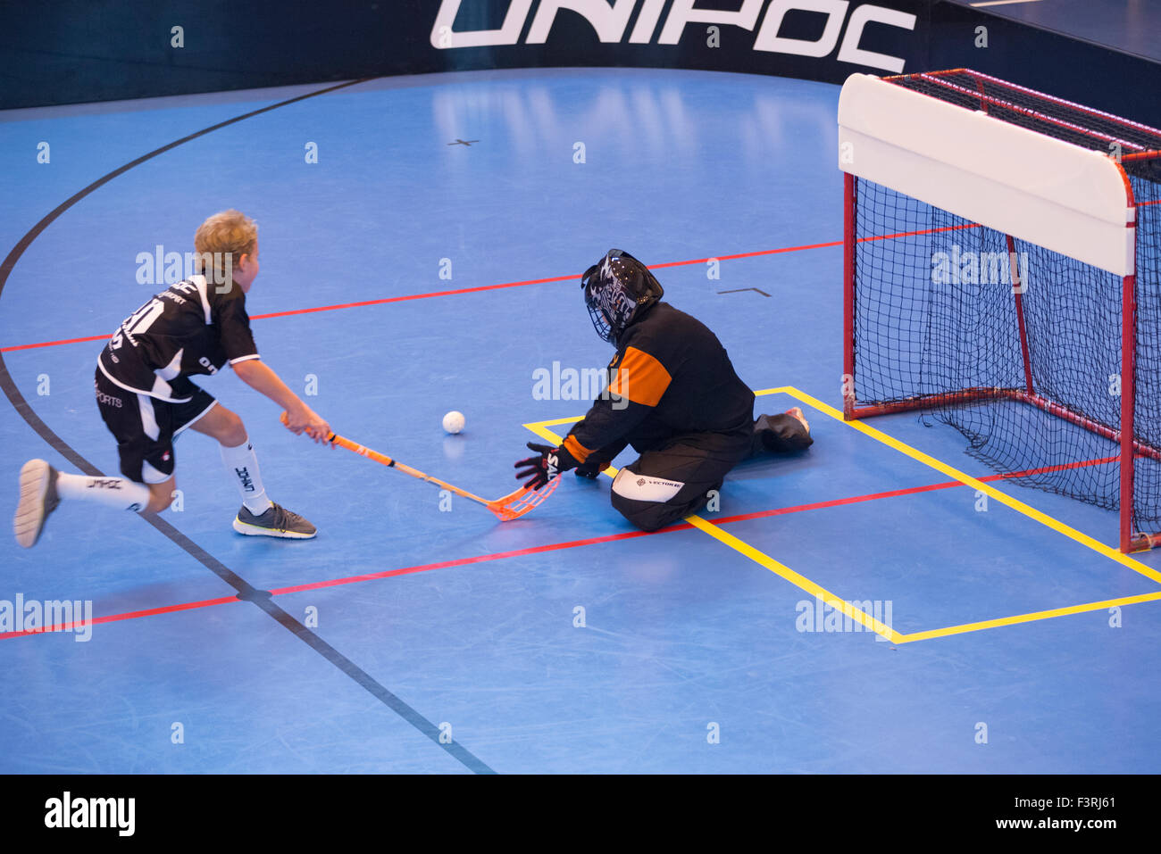 Children boys schoolchildren playing floorball (floor hockey) match in