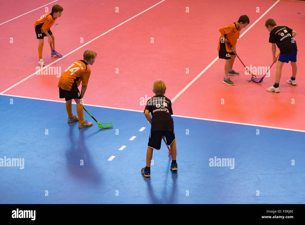 Children boys schoolchildren playing floorball (floor hockey) match in