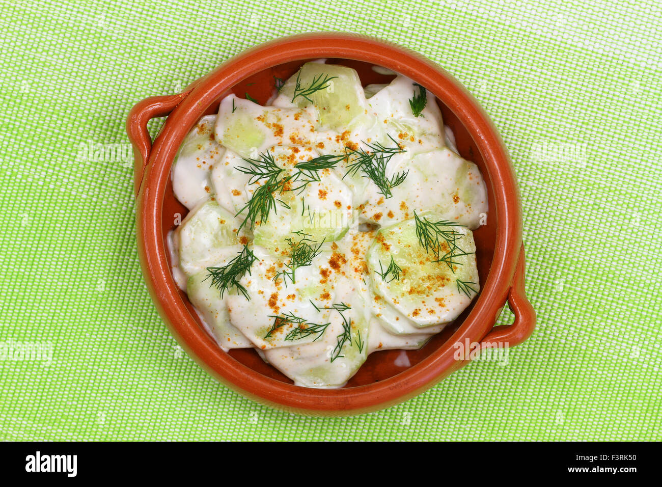 Cucumber in sour cream with  paprika and fresh dill Stock Photo