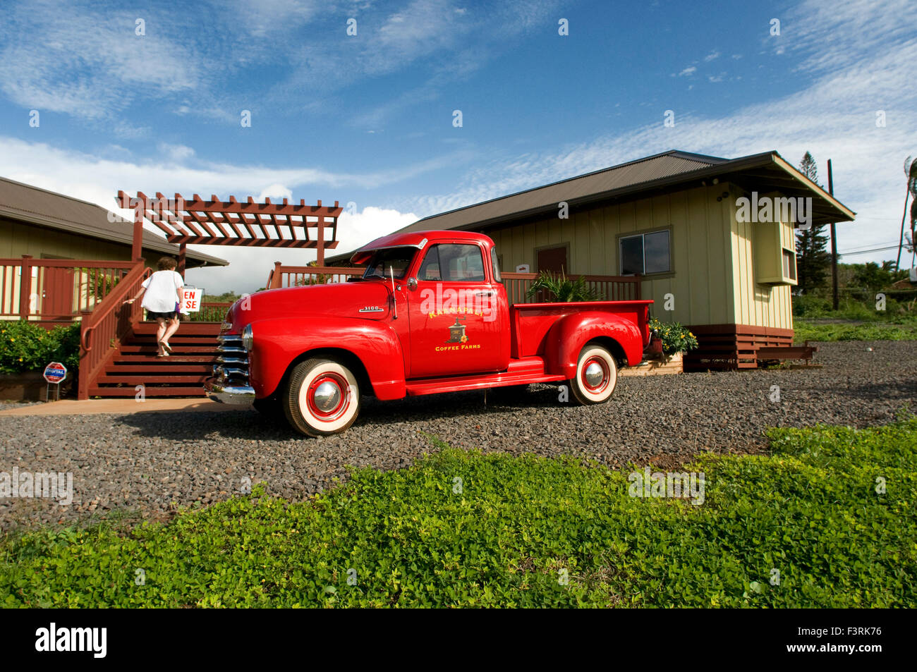 Vintage customized red pickup truck cruising on Ka’anapali coffee farm. Ka‘anapali Coffee Farms occupies a piece of what was onc Stock Photo