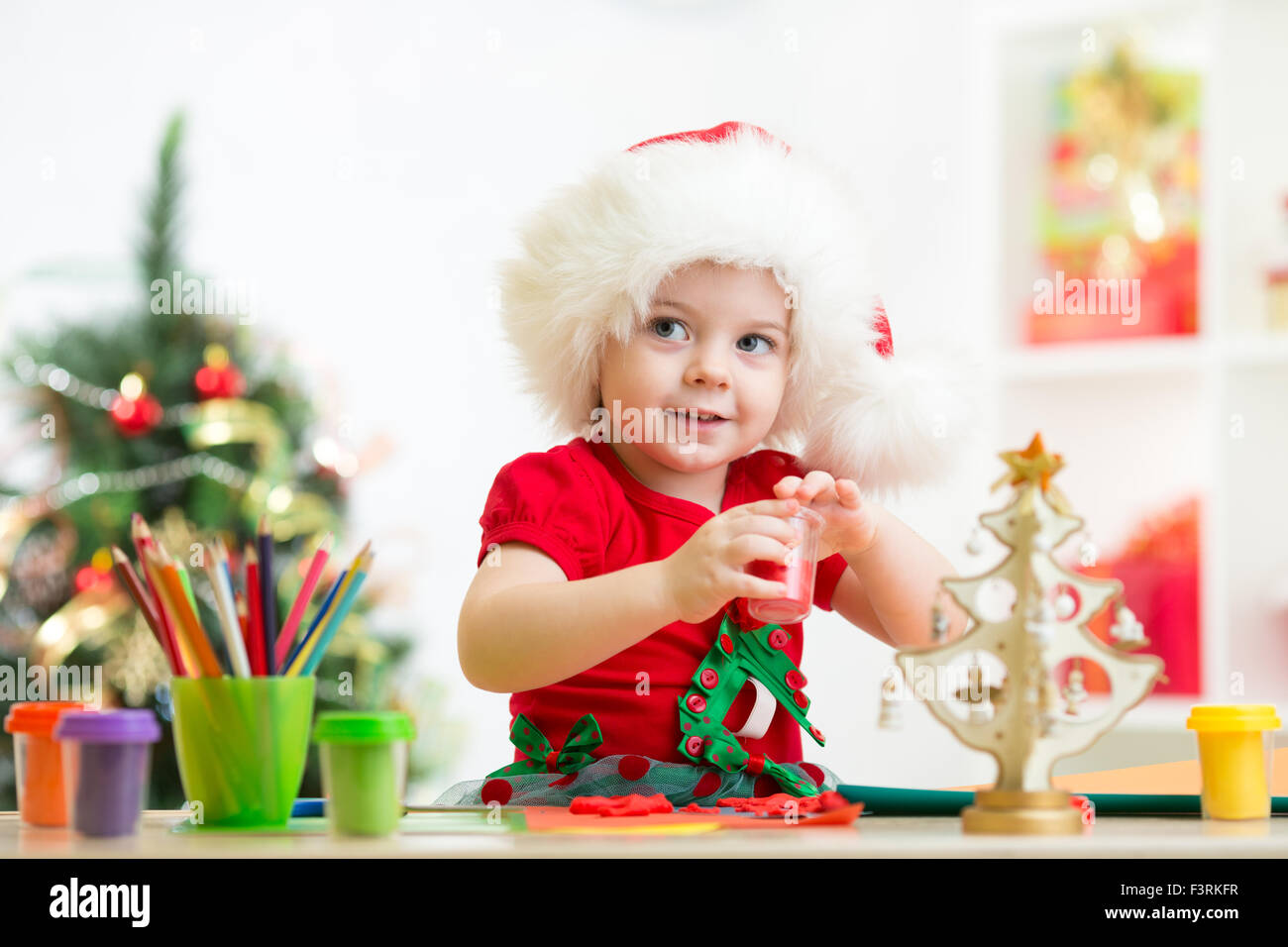 child girl making christmas decorations with play clay toy Stock Photo