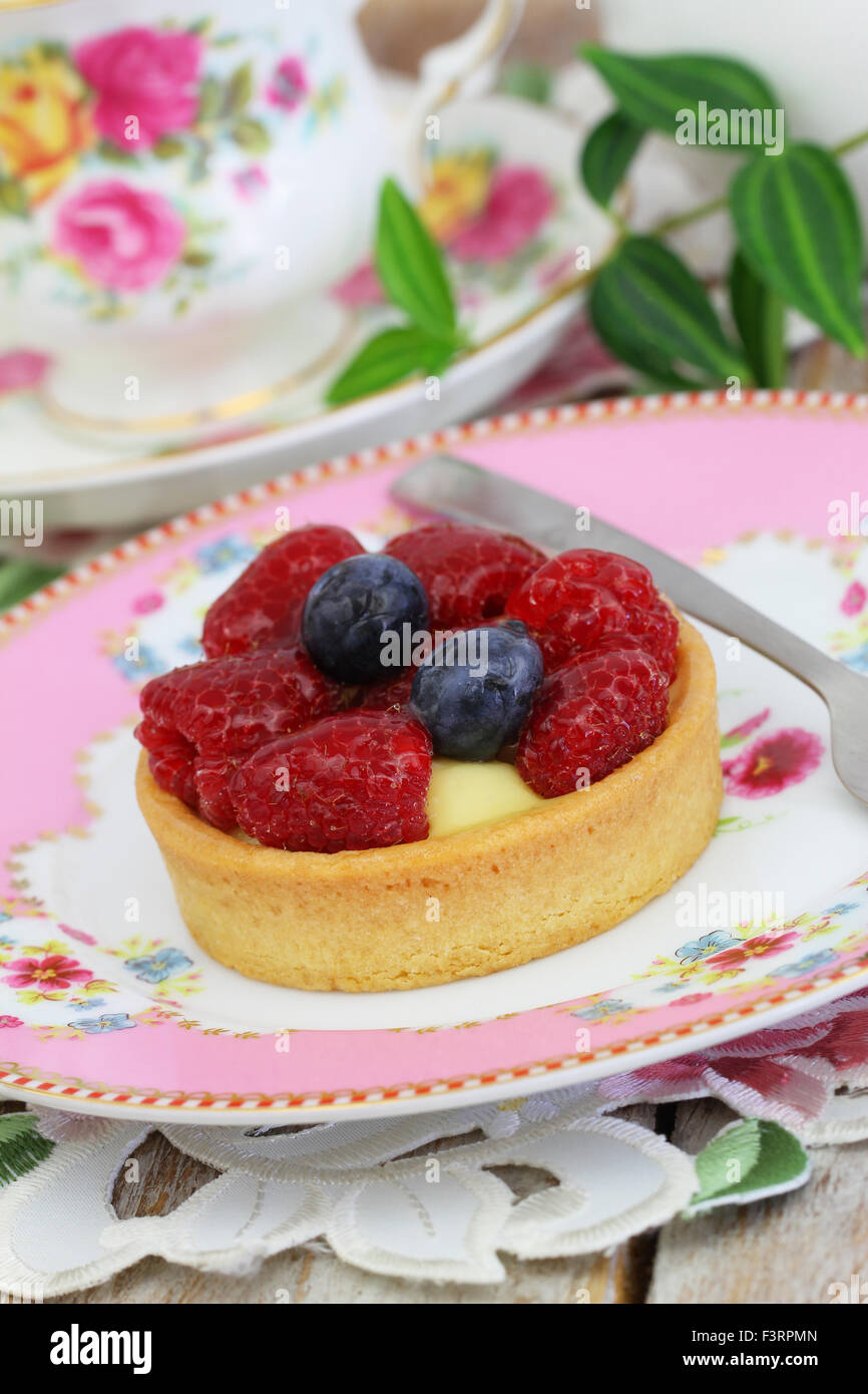 Delicious crunchy cream cake with fresh raspberries and blueberries Stock Photo