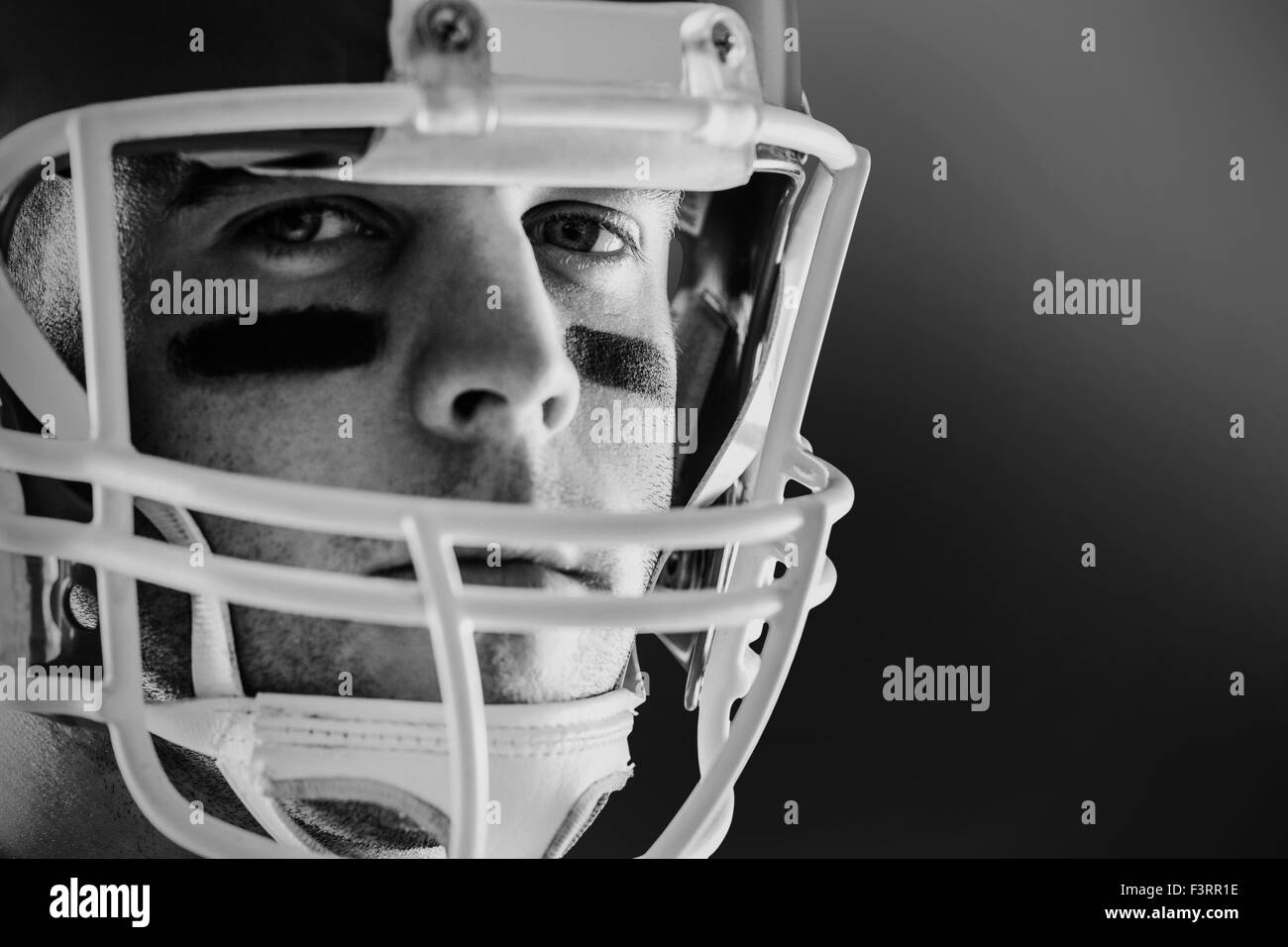 Composite image of portrait of rugby player wearing shoulder pads and  holding helmet Stock Photo - Alamy