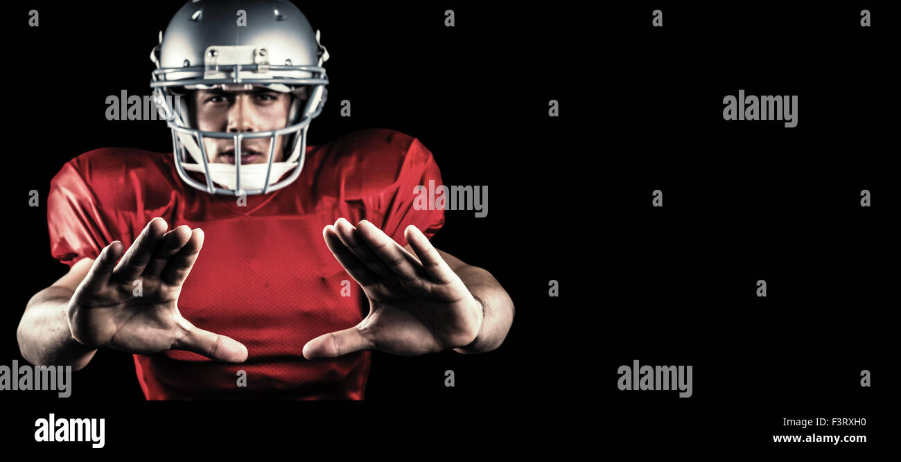 Composite image of portrait of sportsman defending while playing american football Stock Photo