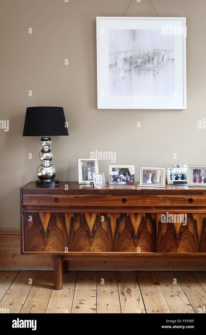 Decorative wooden sideboard with picture frames, lamp and picture frame