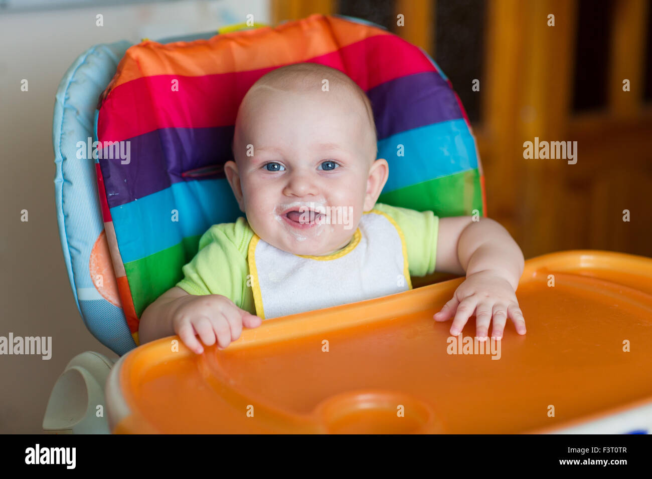 Adorable baby eating in high chair. Baby's first solid food Stock Photo Alamy