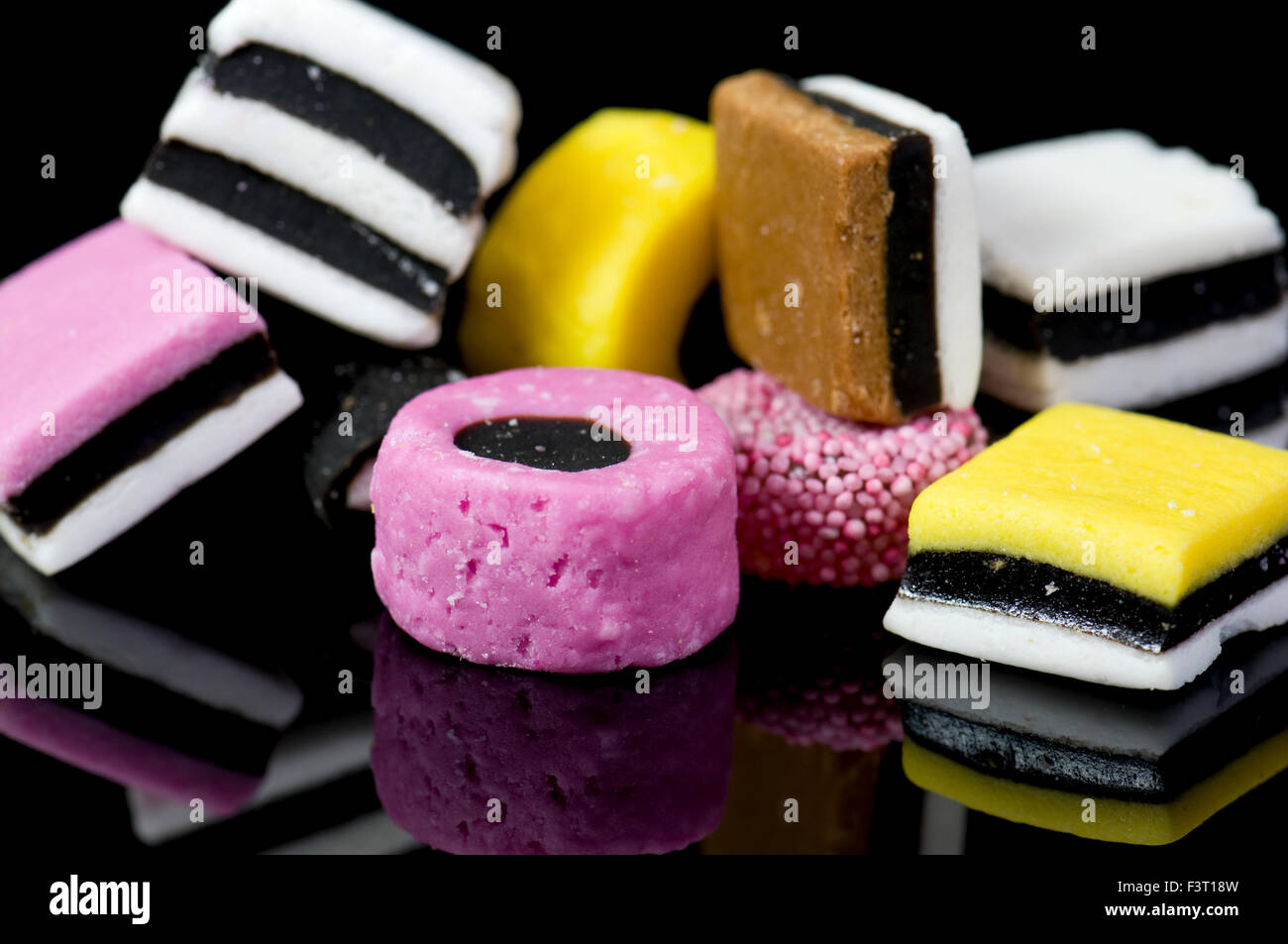 Close up of liquorice allsorts on black reflective background Stock
