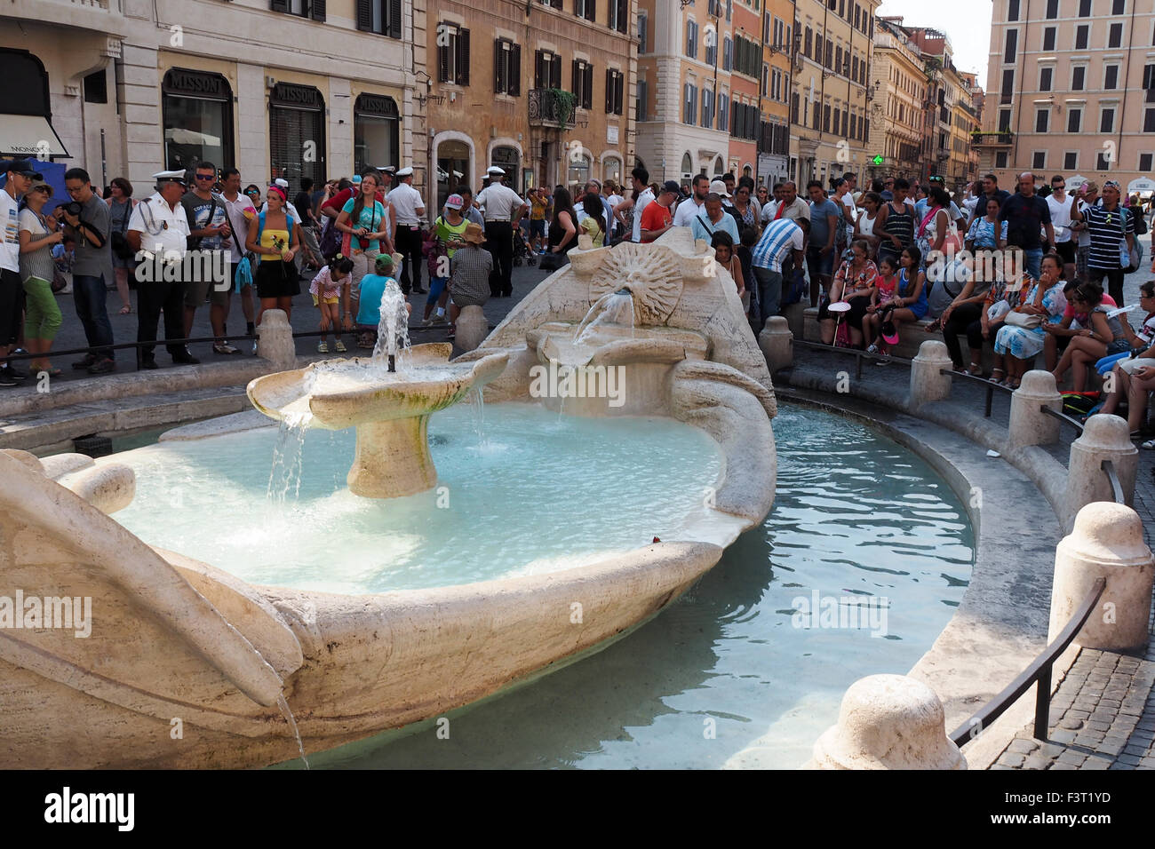 Tourists milling around the Fountain of the Ugly Boat, (Fontana della Barcaccia) in the Piazza di Spagna, Rome. Stock Photo