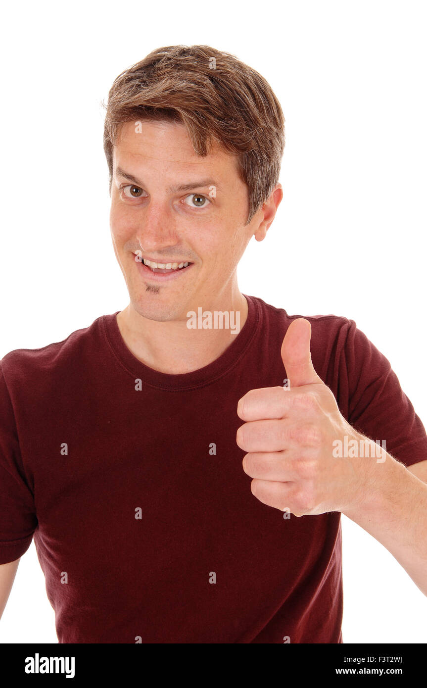 A closeup picture of a young man in a burgundy t-shirt, smiling with one thump up, isolated for white background. Stock Photo