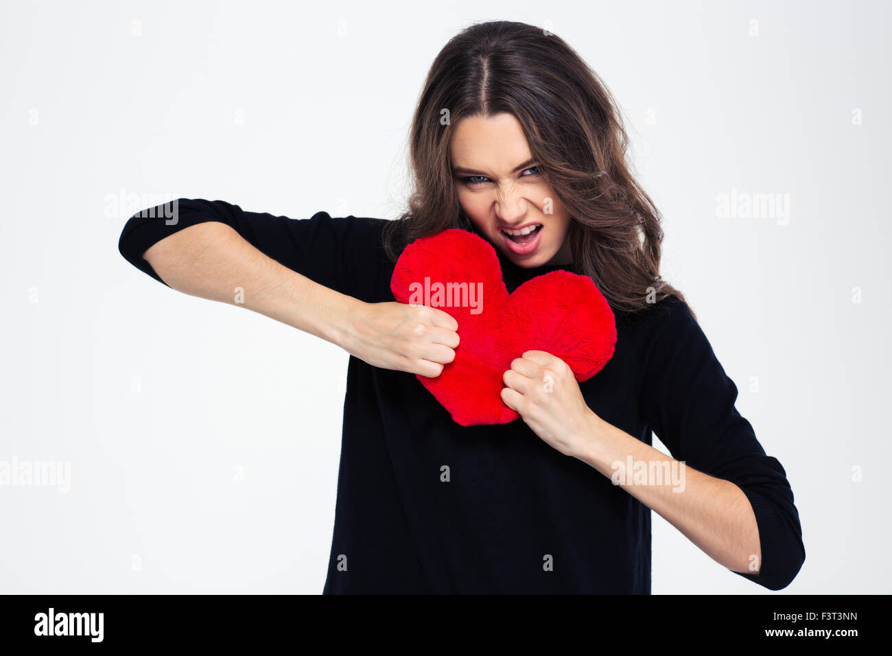 Portrait of a young girl breaking heart isolated on a white background ...