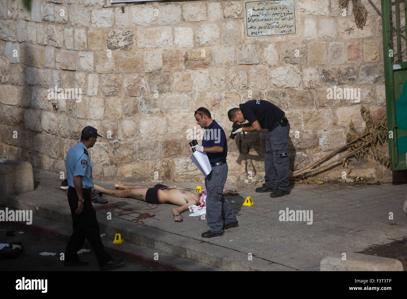 Jerusalem, Israel. 12th October, 2015. Israeli police inspect the body of a Palestinian man who was shot and killed by Israeli police near the Lion Gate in the Old City of Jerusalem, on Oct. 12, 2015. Police shot and killed a Palestinian who allegedly tried to stab them in Jerusalem on Monday, authorities said. According to an initial investigation, a Palestinian man raised the suspicion of police officers at the scene as he walked down the street, police spokesperson Micky Rosenfeld told Xinhua. Credit:  Xinhua/Alamy Live News Stock Photo