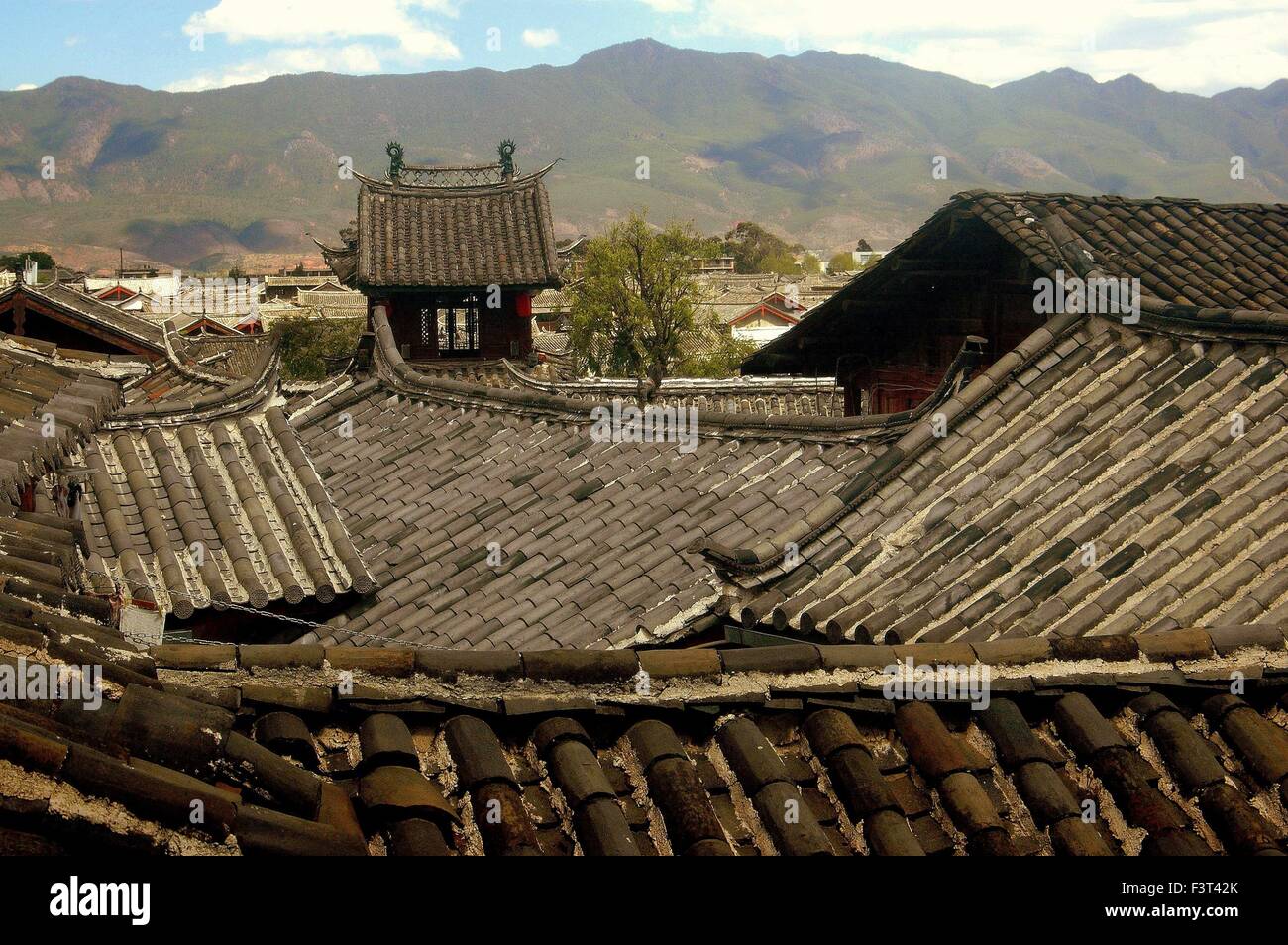 Lijiang, China:  View over the slate gray rooftops of historic Naxi houses and distant mountains Stock Photo