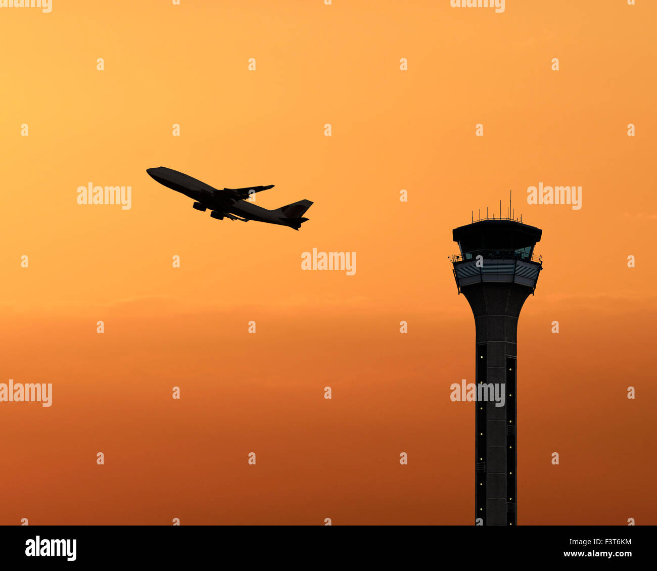 Air traffic control tower with a plane taking off at sunset. Luton Airport, UK. Stock Photo