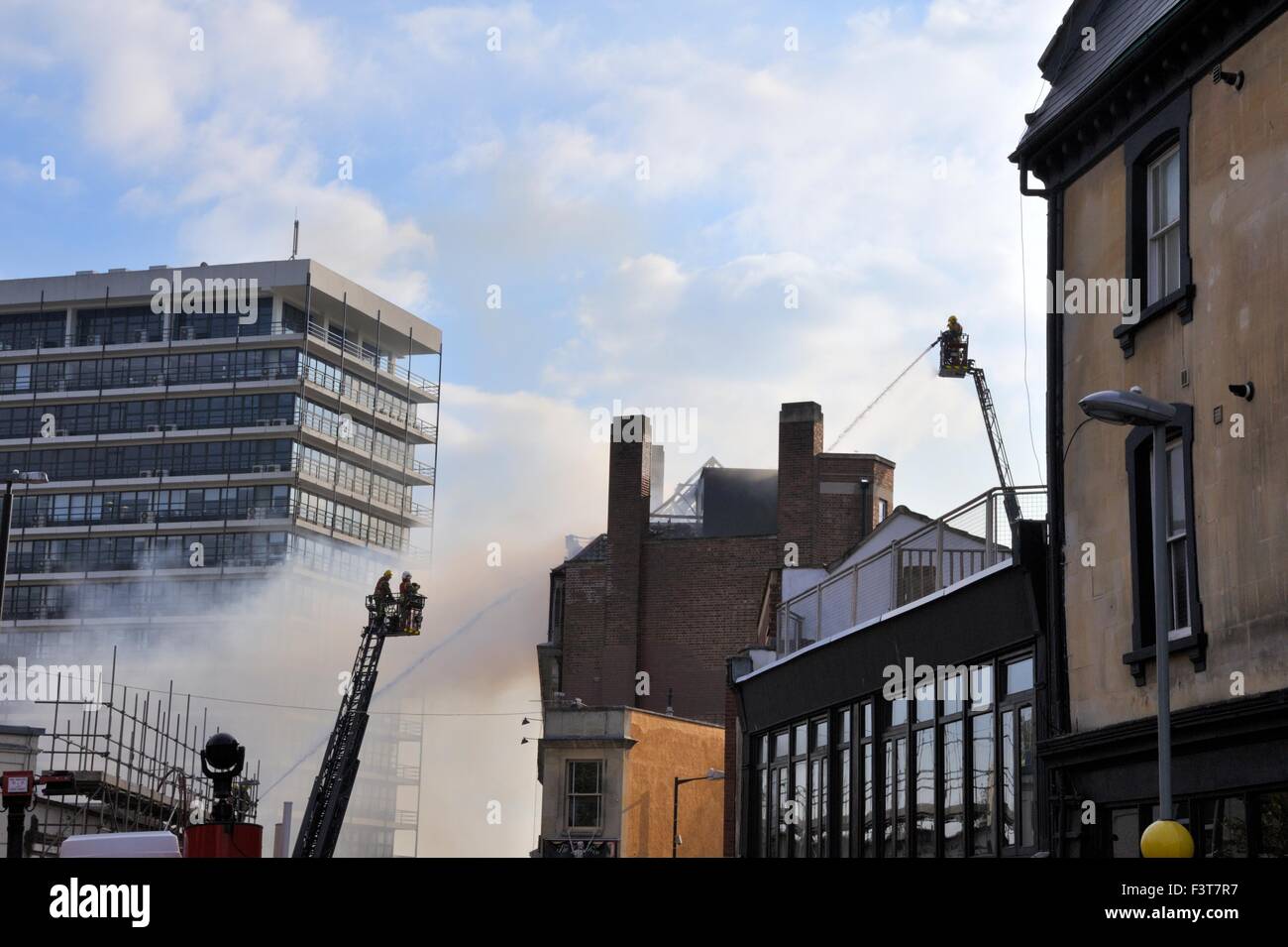Bristol, UK. 12th October, 2015. A major fire started about 13:00hr in University of Bristol Student accommodation, 33 Colston Street, Bristol, England, 12 October 2015, tackled by Avon Fire & Rescue services with two turntable ladder fire engines and more than four other engines. The location is between the Colston Hall and Griffin pub near the junction of Colston Street and Trenchard Street and these roads have been closed to both vehicles and pedestrians. The blaze has completely destroyed the whole length of roof and top floor. Credit:  Charles Stirling/Alamy Live News Stock Photo