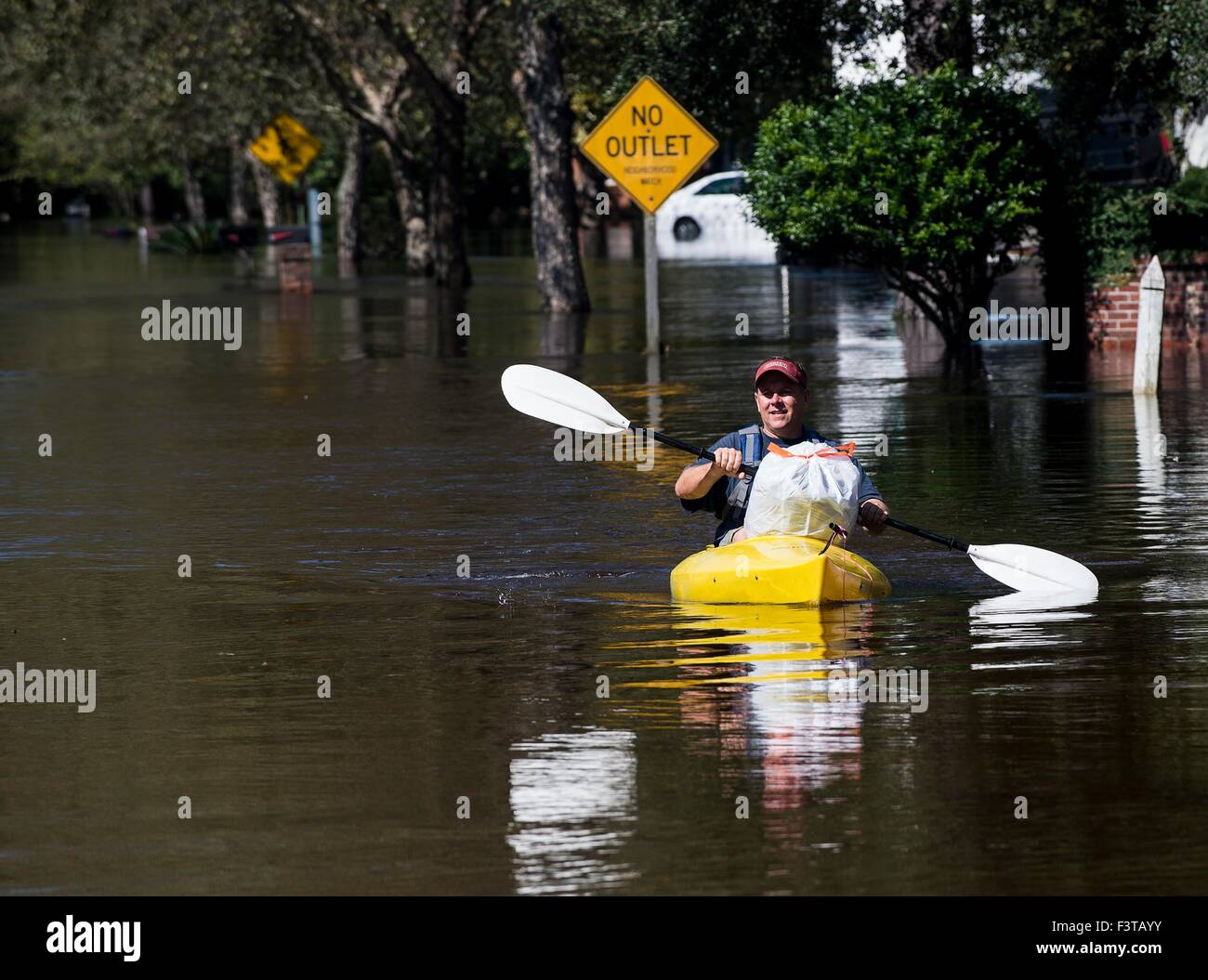 A resident of the Ashborough subdivision paddles a kayak through floodwaters October 8, 2015 in Summerville, South Carolina. Large parts of South Carolina suffered from record setting rains that flooded large portions of the state. Stock Photo