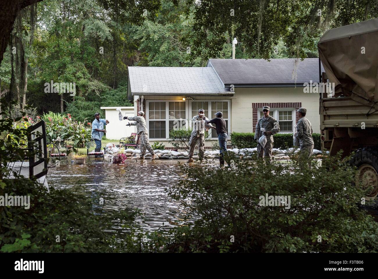 South Carolina National Guard Soldiers unload sandbags to help a resident protect their property from floodwaters October 9, 2015 in Parkers Ferry, South Carolina. Large parts of South Carolina suffered from record setting rains that flooded large portions of the state. Stock Photo