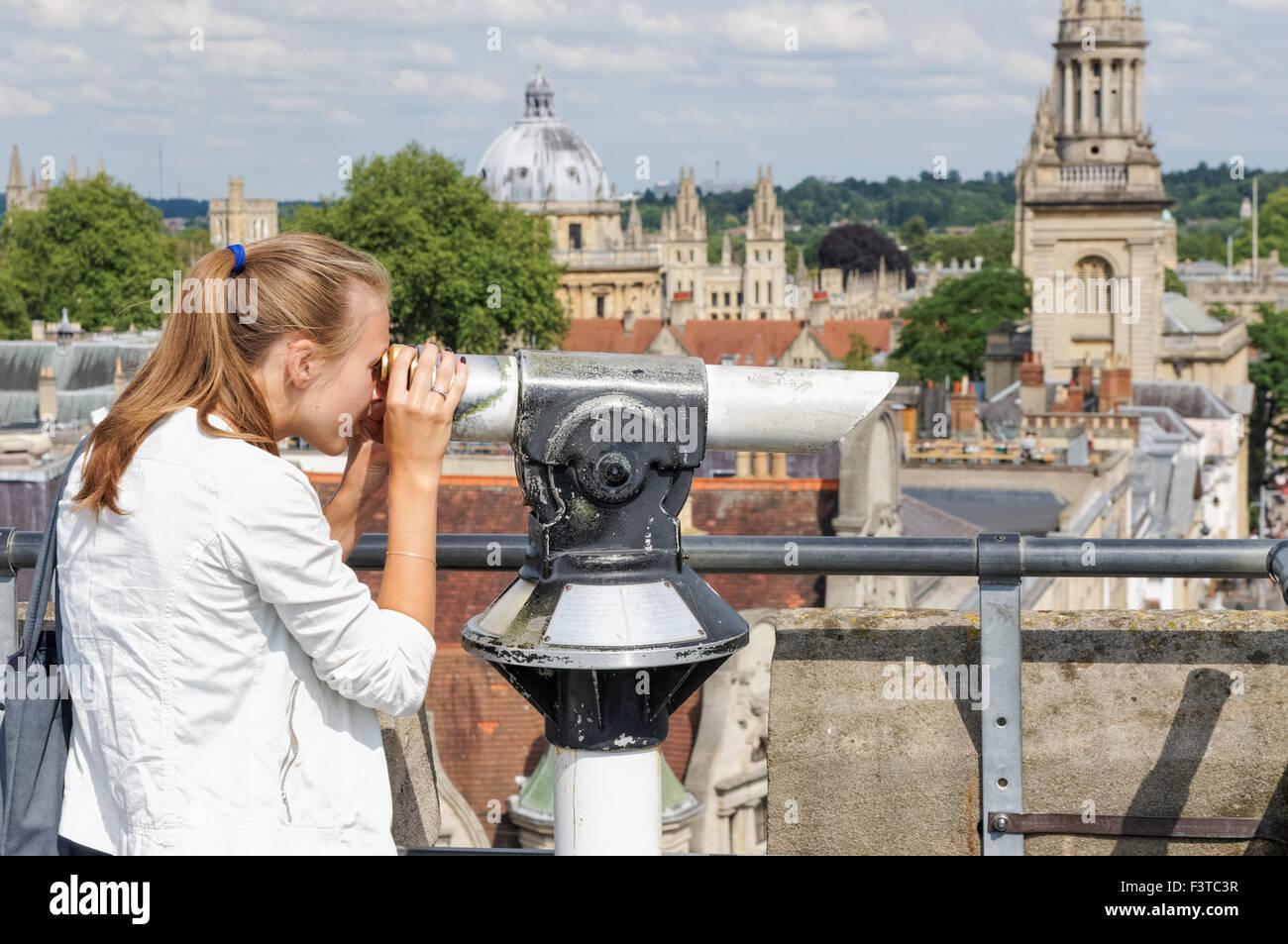 Woman looking through telescope at the top of St Martin's Tower, Carfax Tower in Oxford Oxfordshire England United Kingdom UK Stock Photo