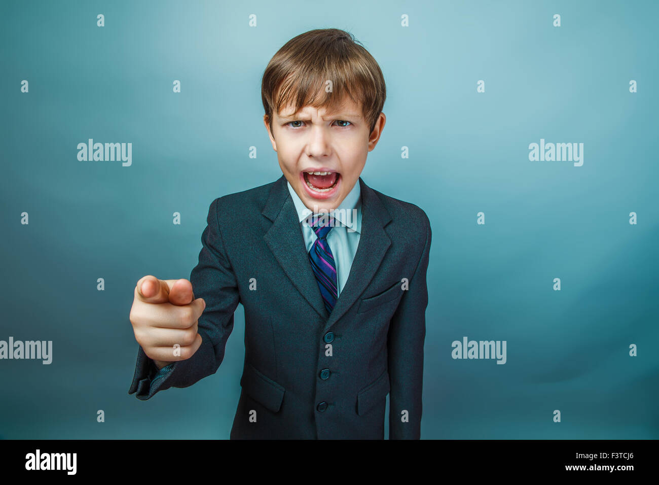 European appearance teenager boy in a business suit points a fin Stock Photo