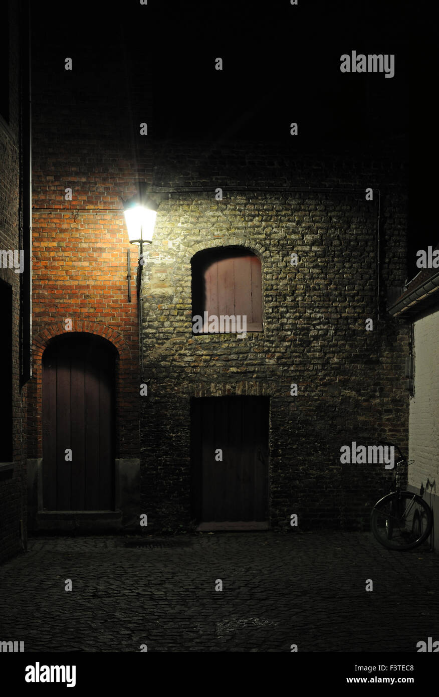 A quiet alleyway at night in the historic centre of Bruges, West-Vlaanderen, Belgium Stock Photo