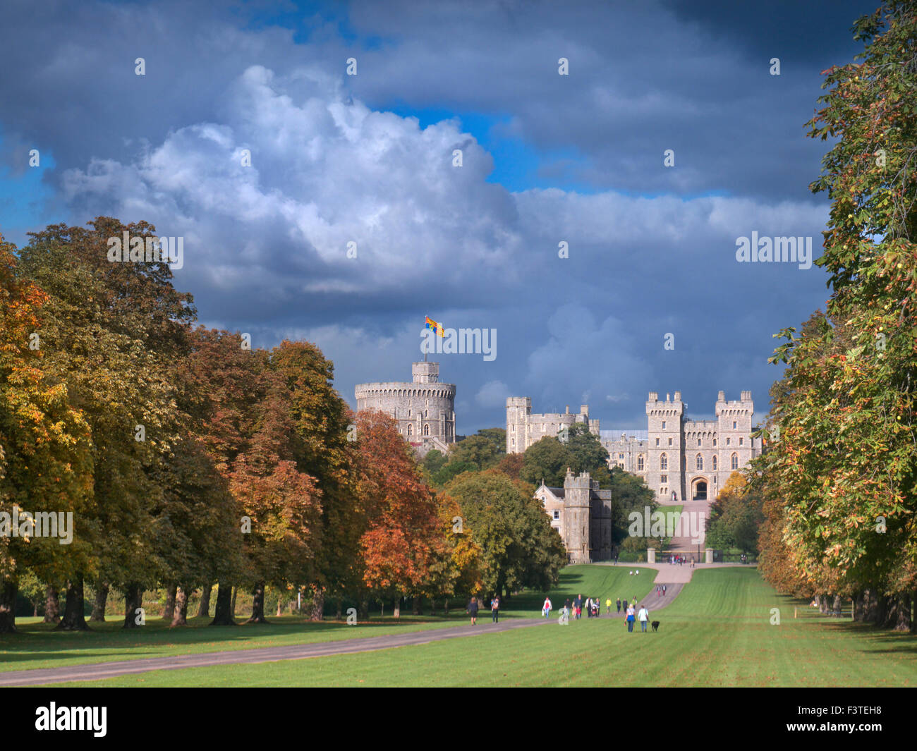 Windsor Castle flying Royal Standard 'HM Queen in residence; viewed down the Long Walk with walkers, in autumnal colour with dramatic sky Berkshire UK Stock Photo
