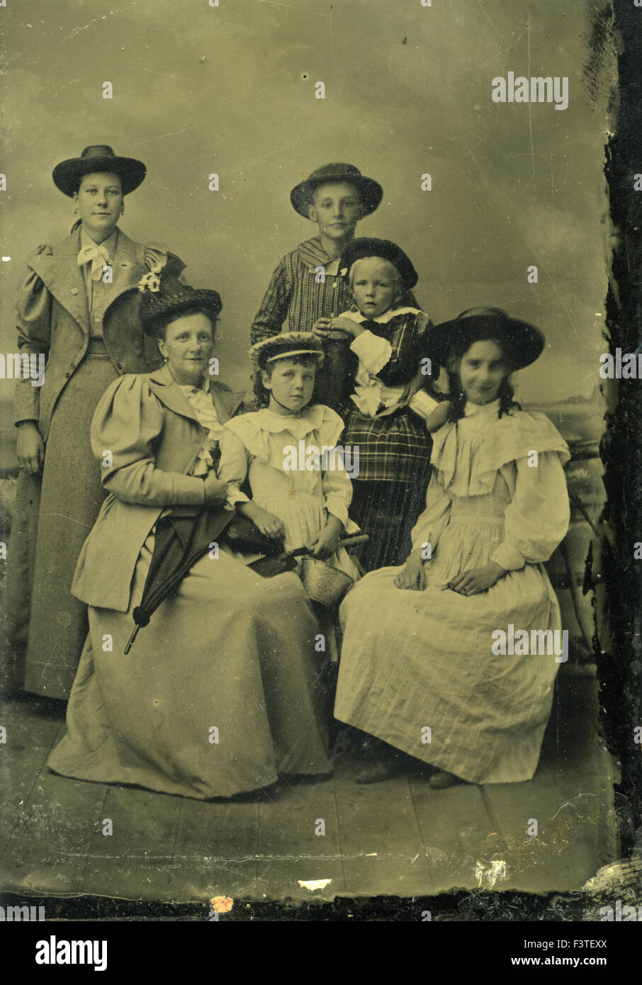 Family dressed in victorian style clothing and hats during a photo sitting that produced a tin-type photograph during the late 1800s in the United States of America. Stock Photo