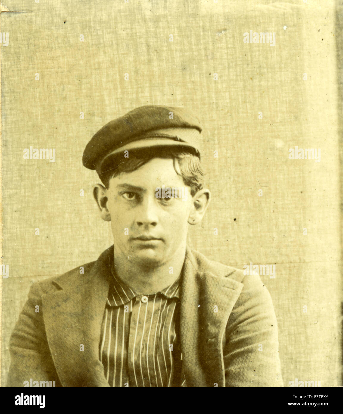 Young man in a shirt coat and hat during a photo sitting that produced a tin-type photograph during the late 1800s in the United States of America. Stock Photo