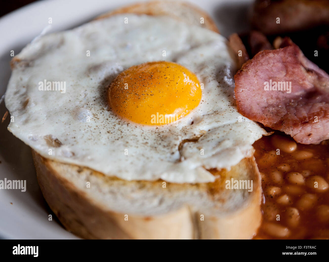 pepper fried egg on toast with bacon beans Stock Photo
